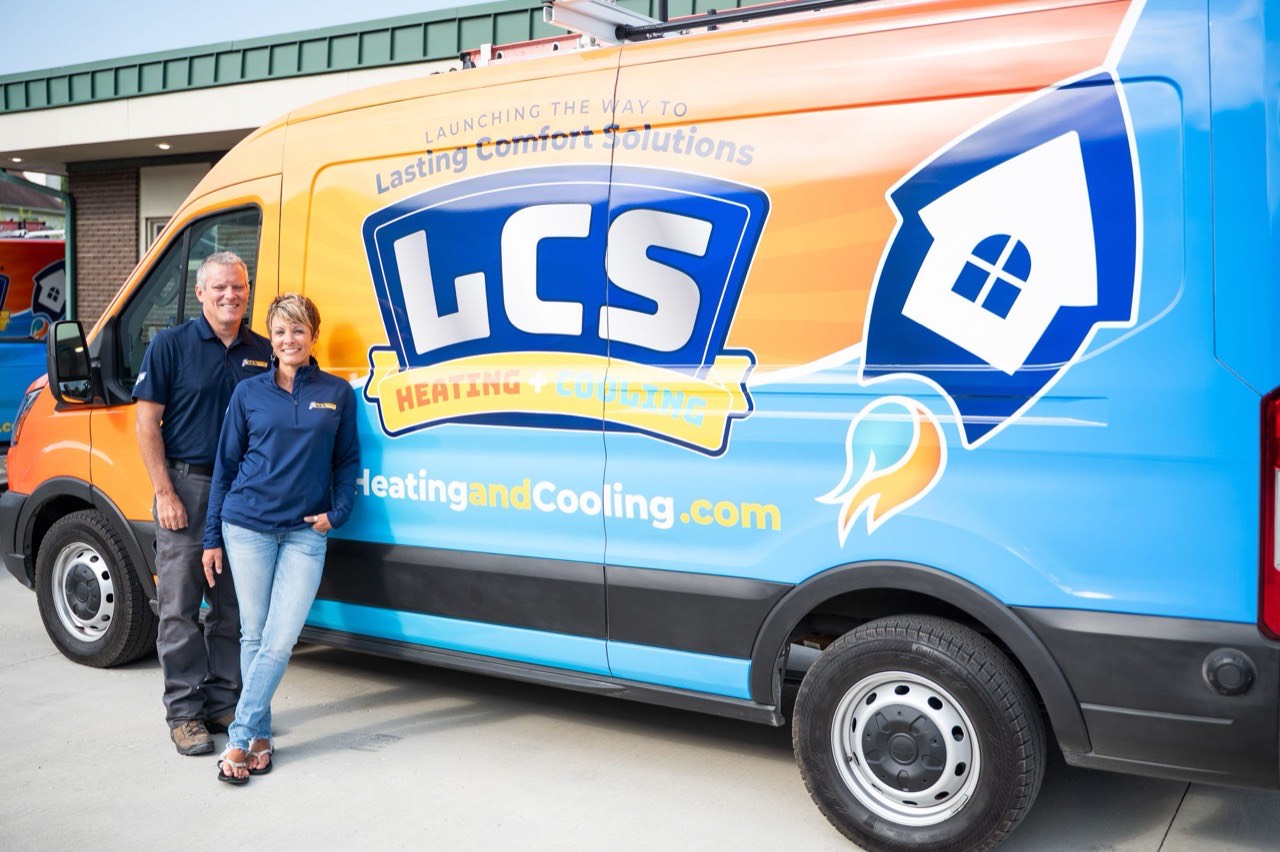 Travis and Renee Lucas, founders of LCS Heating and Cooling, in front of an LCS service van