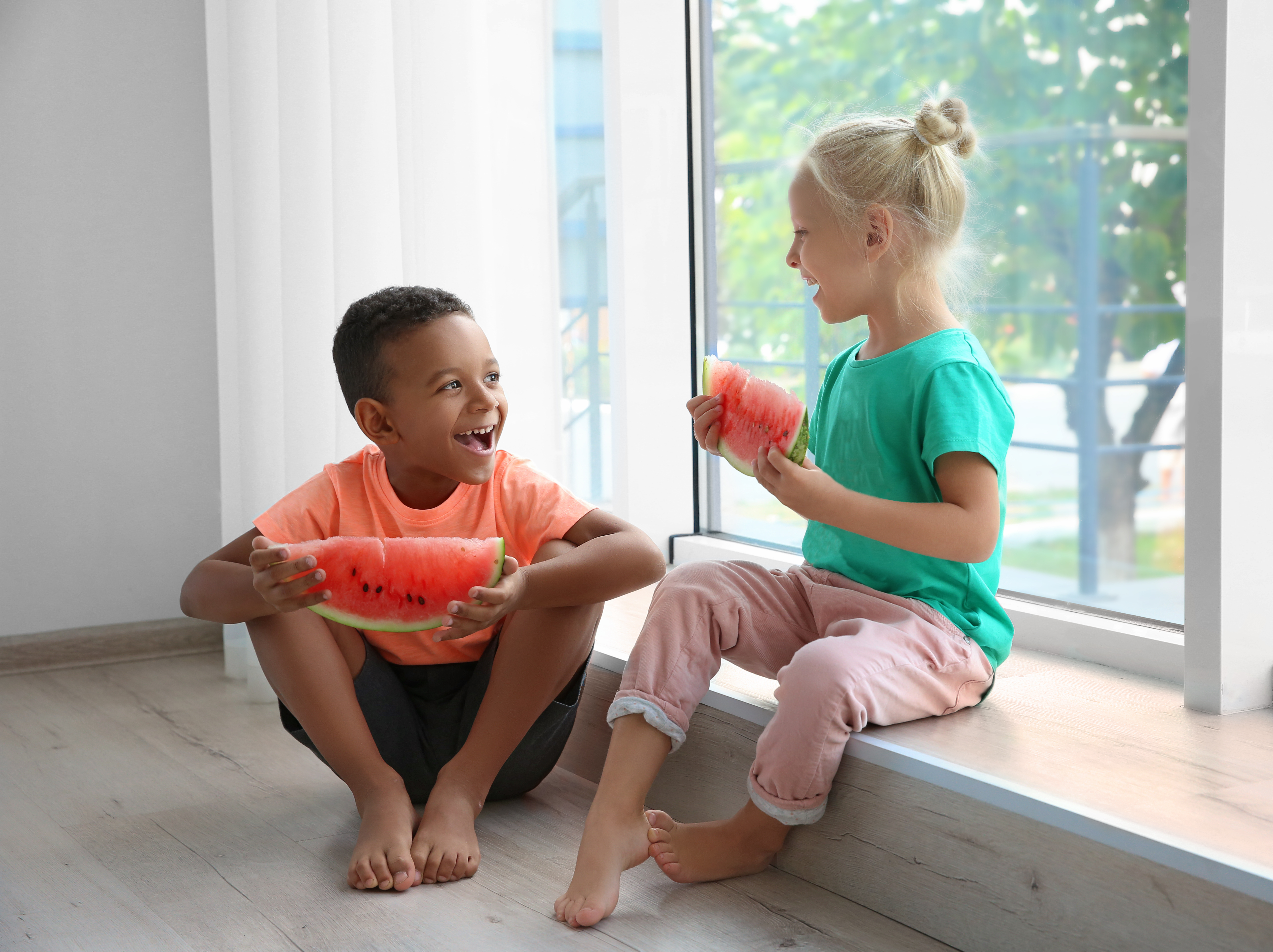 two kids eating watermelon