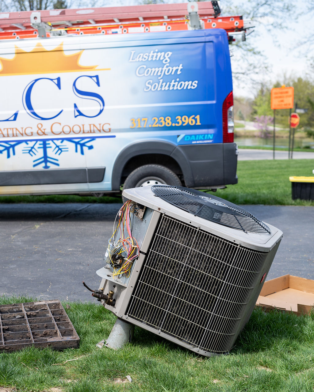 Old AC unit next to an LCS Heating and Cooling van scheduled for replacement hvac