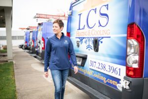 Renee Lucas, owner of LCS Heating and Cooling in Indianapolis, Indiana walking past the fleet of HVAC vans that carry supplies for customers.